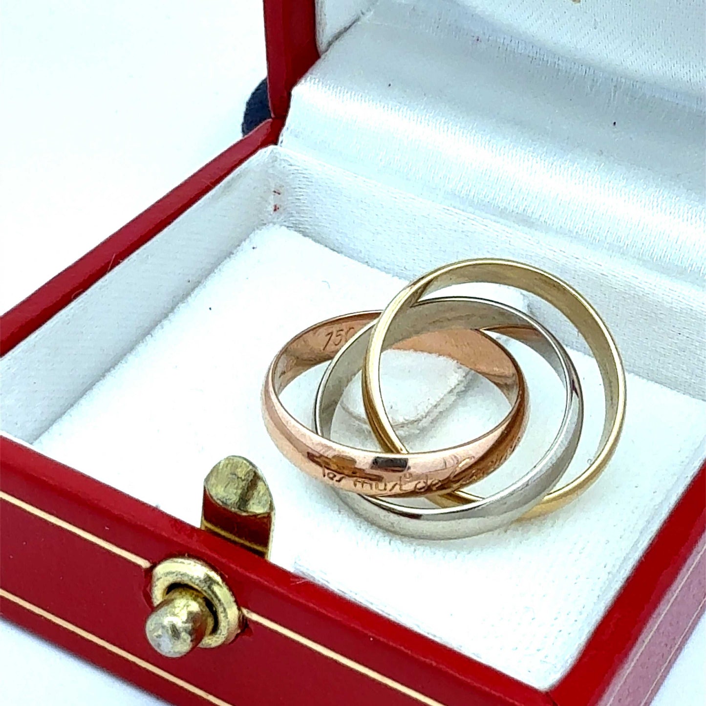 Cartier Trinity Ring aus Gold und Weißgold, detailreiche Gestaltung, mit Original-Zertifikat, auf weißem Hintergrund.